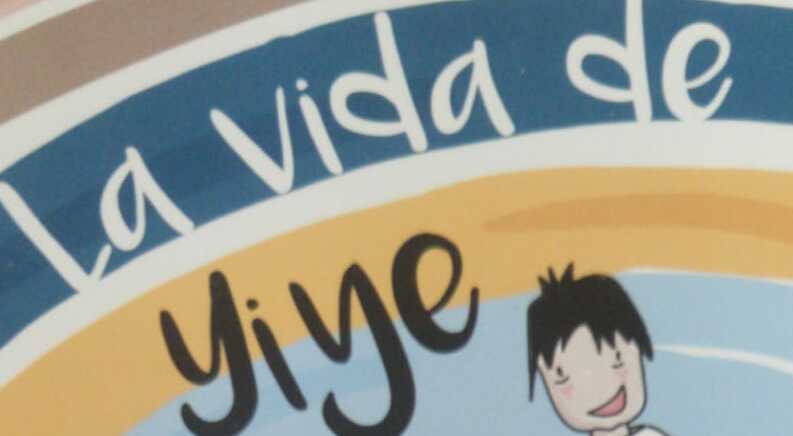 Una encantadora sección de un letrero muestra con orgullo el texto "La vida de Yiye", acompañado de un personaje de dibujos animados caprichoso, que captura perfectamente la esencia de la narración.